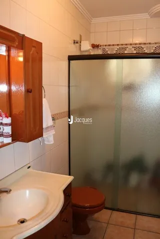 Foto de um banheiro interno com azulejos brancos e louças sanitárias.