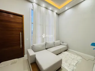 Uma sala de estar clara com um sofá branco e tapete fofo.