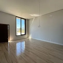 Sala de estar com piso de madeira e janela.