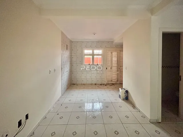 Corredor interno com piso de cerâmica e paredes brancas.