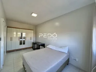 Quarto com cama e paredes brancas em um imóvel.