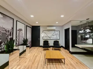 Sala de estar com piso de madeira clara e espelho grande.