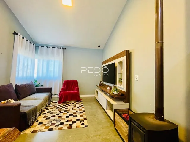 Sala de estar com sofá e poltrona vermelha em um ambiente claro.
