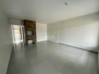 Corredor interno de uma residência com piso de cerâmica e parede de destaque de madeira.