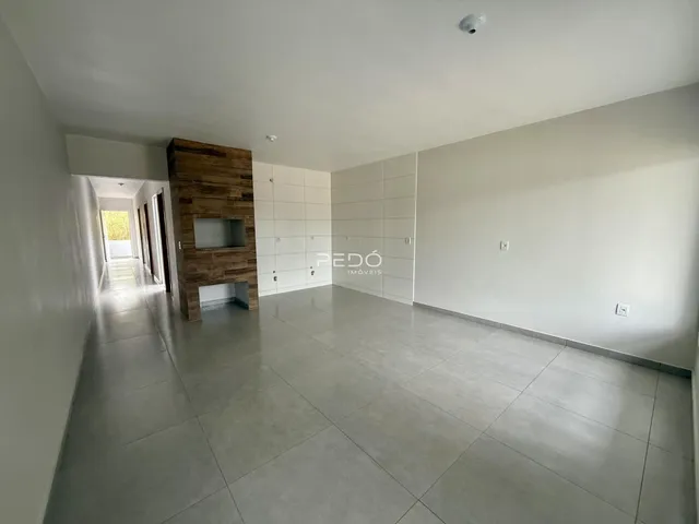 Corredor interno de uma residência com piso de cerâmica e parede de destaque de madeira.