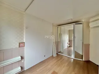 Ambiente interno com piso de madeira e armários embutidos.