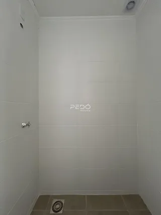 A foto mostra o interior de um banheiro com revestimento cerâmico nas paredes.