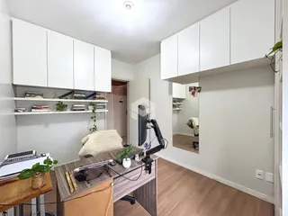 Foto de uma sala de estar com armários brancos e piso de madeira.