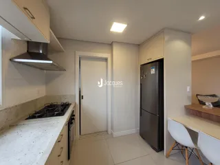 Cozinha moderna com armários e bancada clara.