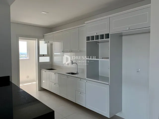 Cozinha moderna com armários brancos e bancadas.