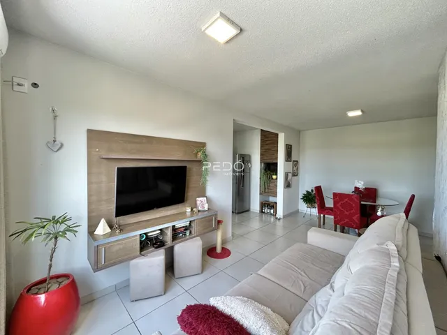 Sala de estar com sofá e painel de TV em um apartamento.