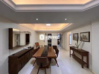 Uma sala de jantar com mesa de madeira e armários em um ambiente claro.