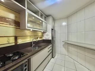Cozinha com armários e piso de cerâmica branca.