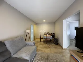 Sala de estar com sofá e mesa de jantar em um imóvel.
