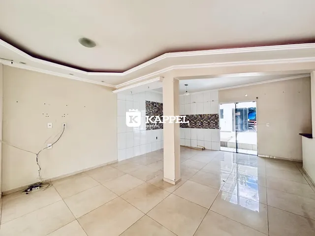 Ambiente interno com piso de cerâmica e paredes claras em uma área comum.
