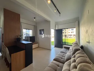 Sala de estar com sofá e painel de madeira em um imóvel no Brasil.