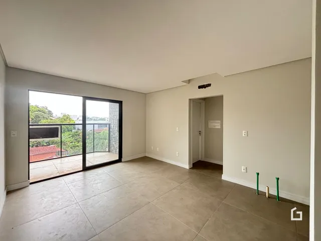 Foto de um ambiente interno com grande porta de vidro que se abre para uma área externa.