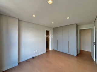 Interior de um cômodo com piso de madeira e armários embutidos.