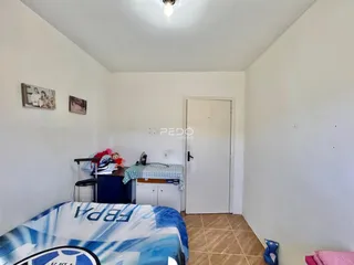 Quarto com cama e decoração nas paredes brancas.