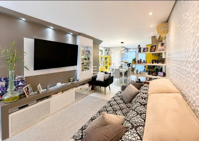 Sala de estar com sofá e televisão em um imóvel no Brasil.