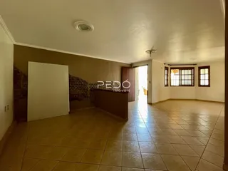 Sala de estar ampla com piso de cerâmica clara.