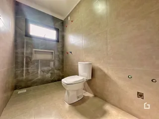 Foto de um banheiro com piso de cerâmica e paredes revestidas.