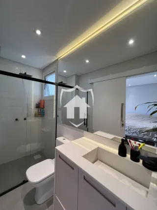 Foto de um banheiro moderno com box de vidro e louças brancas.