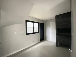 Interior de uma sala com paredes brancas e uma grande janela.