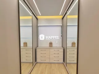 Hall de entrada com armários e espelhos em um ambiente claro.