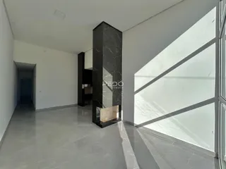 Interior de um ambiente com paredes brancas e piso cinza.