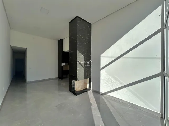 Interior de um ambiente com paredes brancas e piso cinza.
