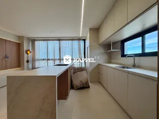 Cozinha moderna com ilha de mármore e grandes janelas.