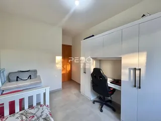 Quarto com armário branco e piso de cerâmica em imóvel no Brasil.