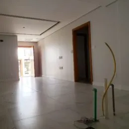 Hall de entrada com paredes brancas e piso claro.