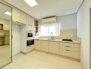 Uma cozinha com armários claros e piso de cerâmica.