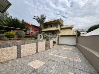 Vista da fachada de uma residência em Lajeado, Brasil, com muro e garagem.