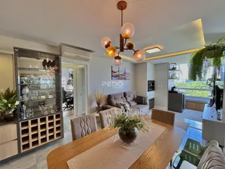 Sala de estar com mesa de jantar de madeira e decoração moderna.