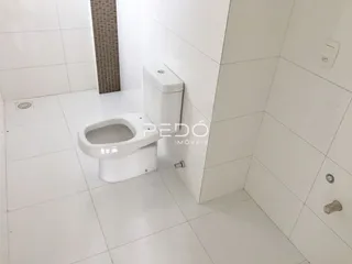 Banheiro com piso cerâmico branco e azulejos nas paredes.
