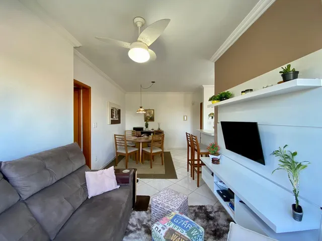 Foto de uma sala de estar com sofá e ventilador de teto em um imóvel.