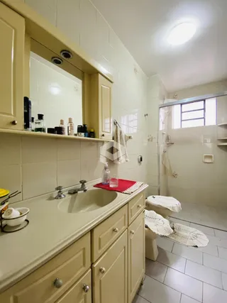 Banheiro com revestimento cerâmico e bancada clara.