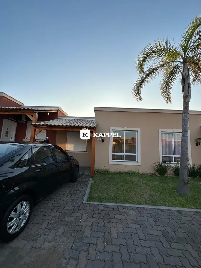 Fachada de uma casa residencial em Lajeado, Brasil, com paisagismo e veículo estacionado na frente.