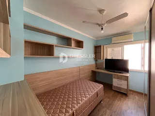 Quarto com cabeceira e painéis de madeira na parede azul claro.