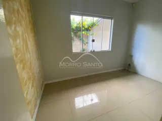Interior de uma sala clara com piso de cerâmica e grande janela.