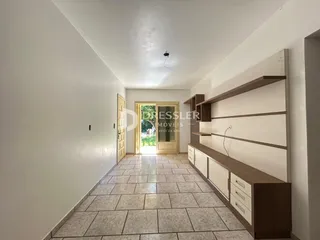 Hall de entrada com piso de cerâmica e estantes em madeira.