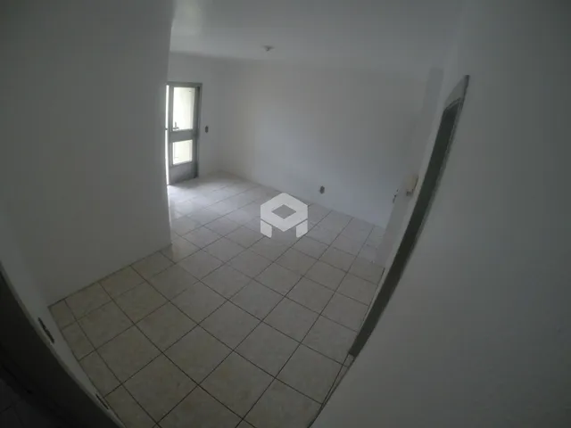Corredor interno com piso de cerâmica claro.