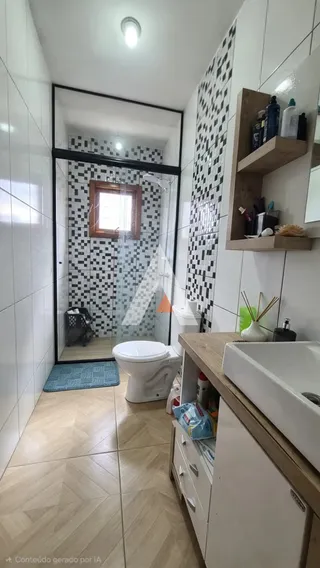 A foto mostra o interior de um banheiro com revestimento branco e piso de madeira clara.