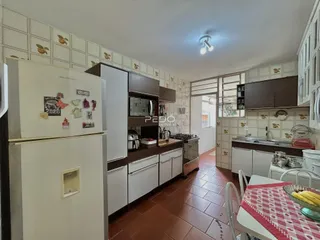 Interior da cozinha com armários brancos e piso de cerâmica na Lajeado.