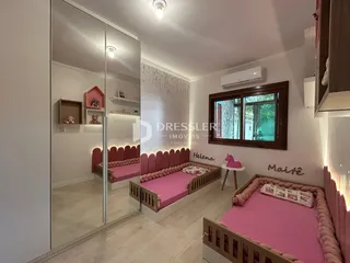 Quarto com camas rosa e decoração de madeira em Lajeado.
