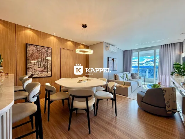 Sala de jantar com mesa branca e cadeiras em um ambiente com painéis de madeira.