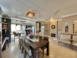 Uma sala de jantar ampla com mesa de madeira e ambiente iluminado.